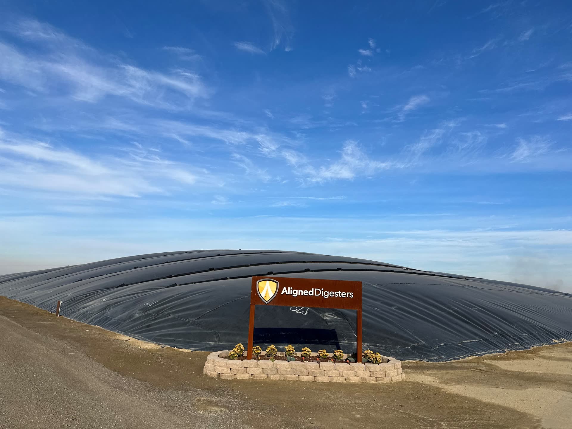 The Aligned Digesters sign in front of a covered lagoon digester